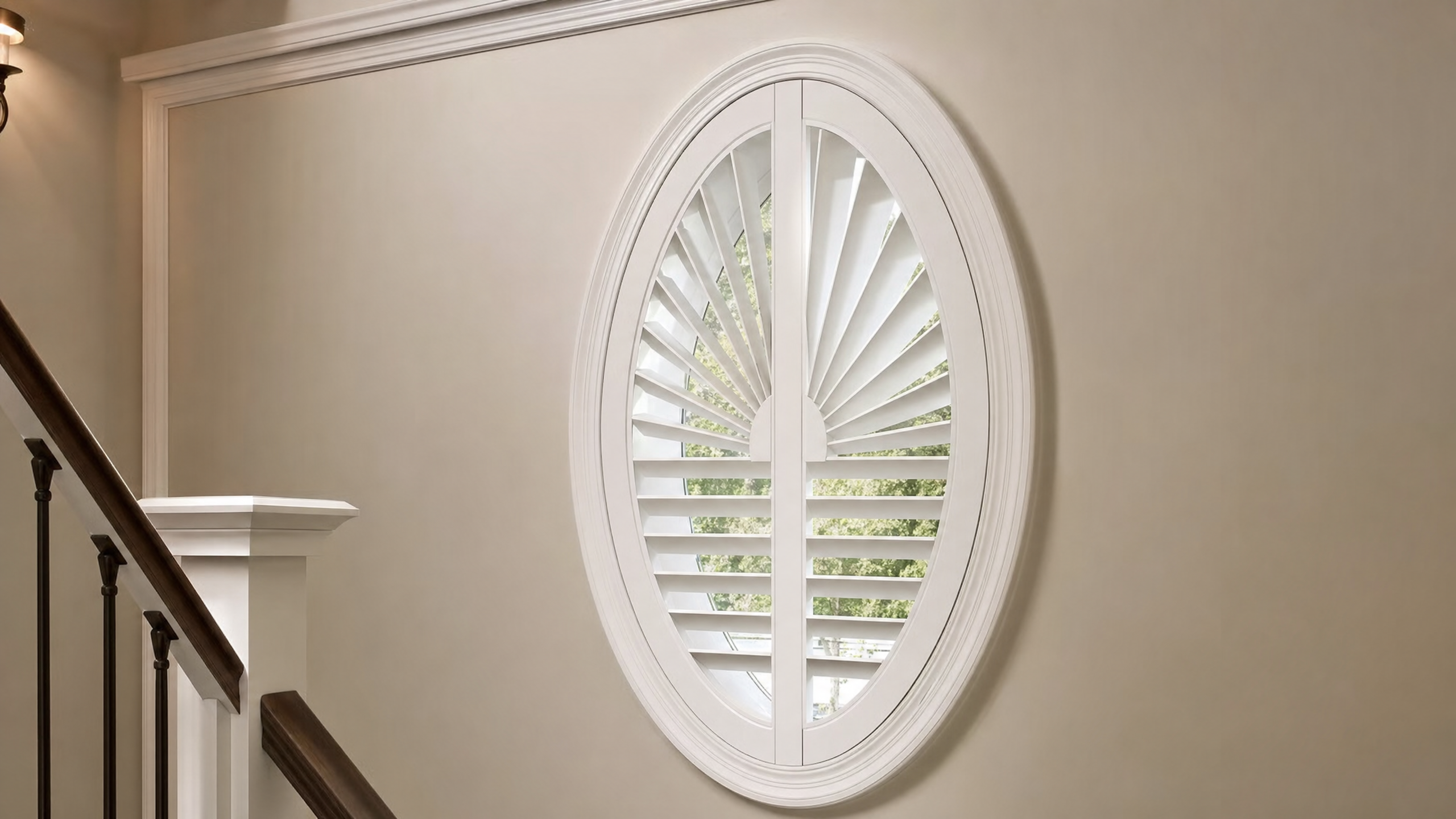 Oval specialty window fitted with custom white plantation shutters